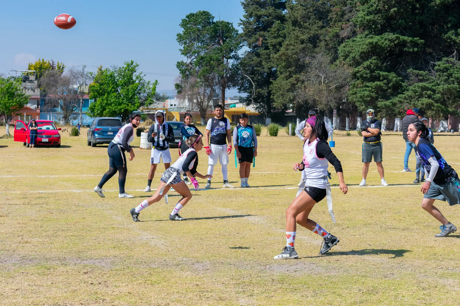 Girls flag football quarterback releasing a pass during a game
