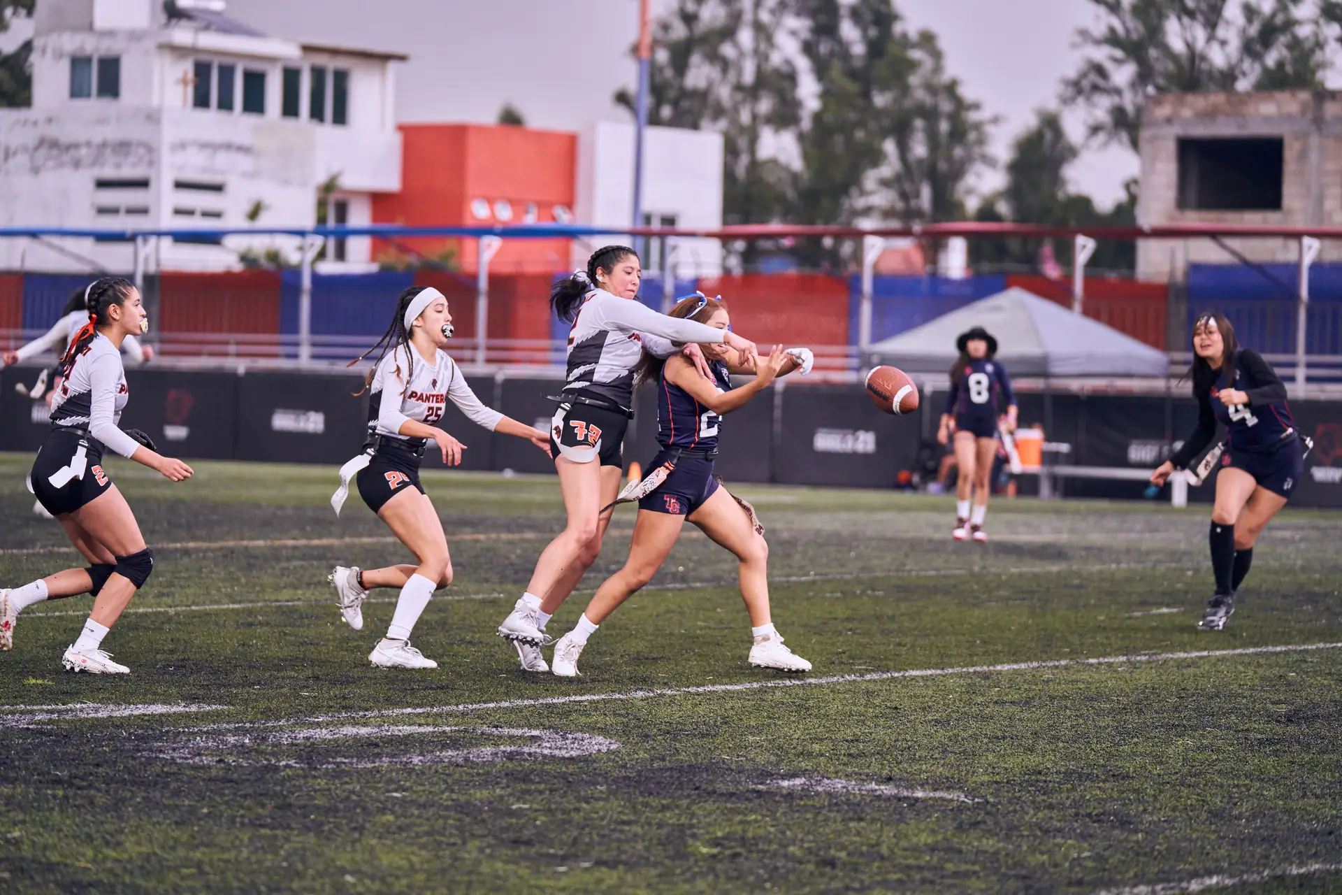 Girls flag football players competing for the ball mid-play